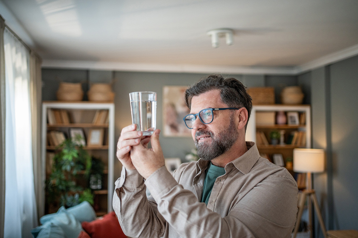 Man looking at glass of water